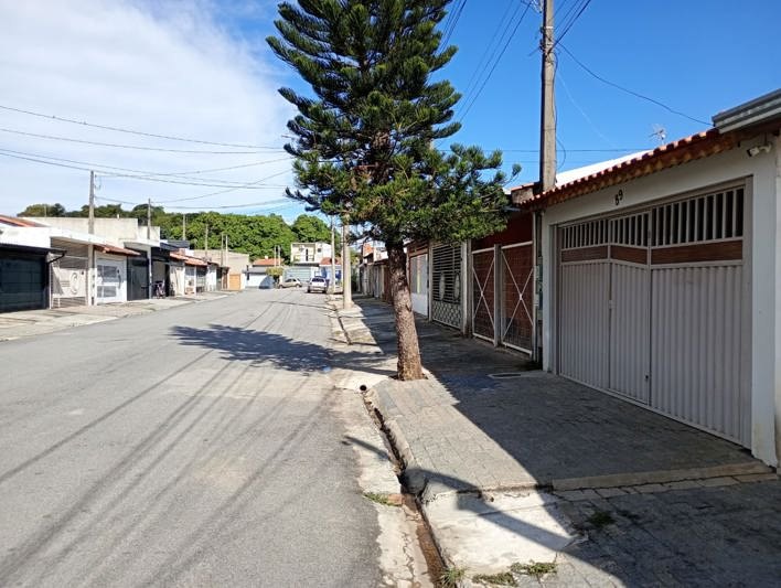 Rua da casa, arborizada e asfaltada