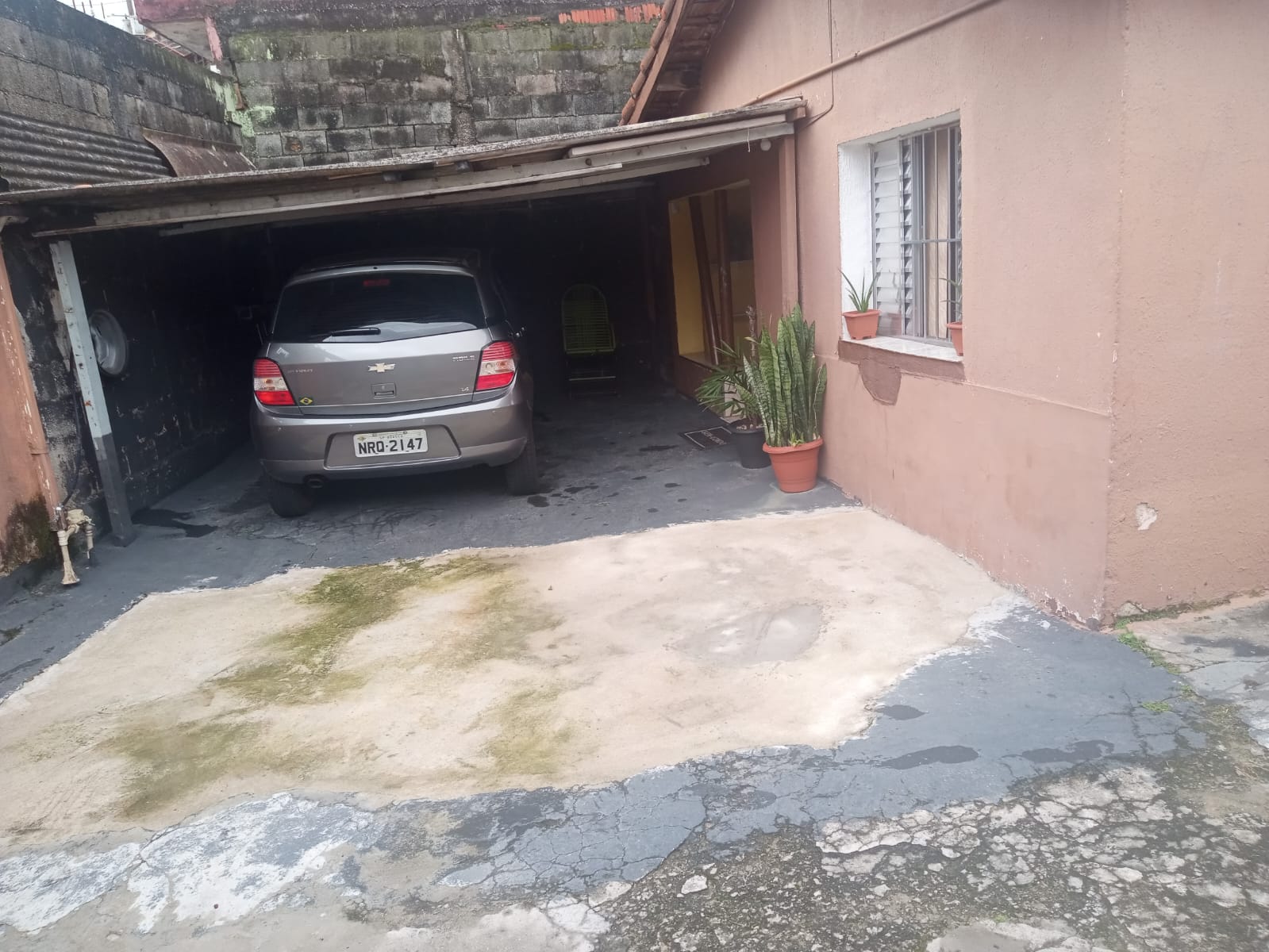 Garagem com carro e entrada da casa