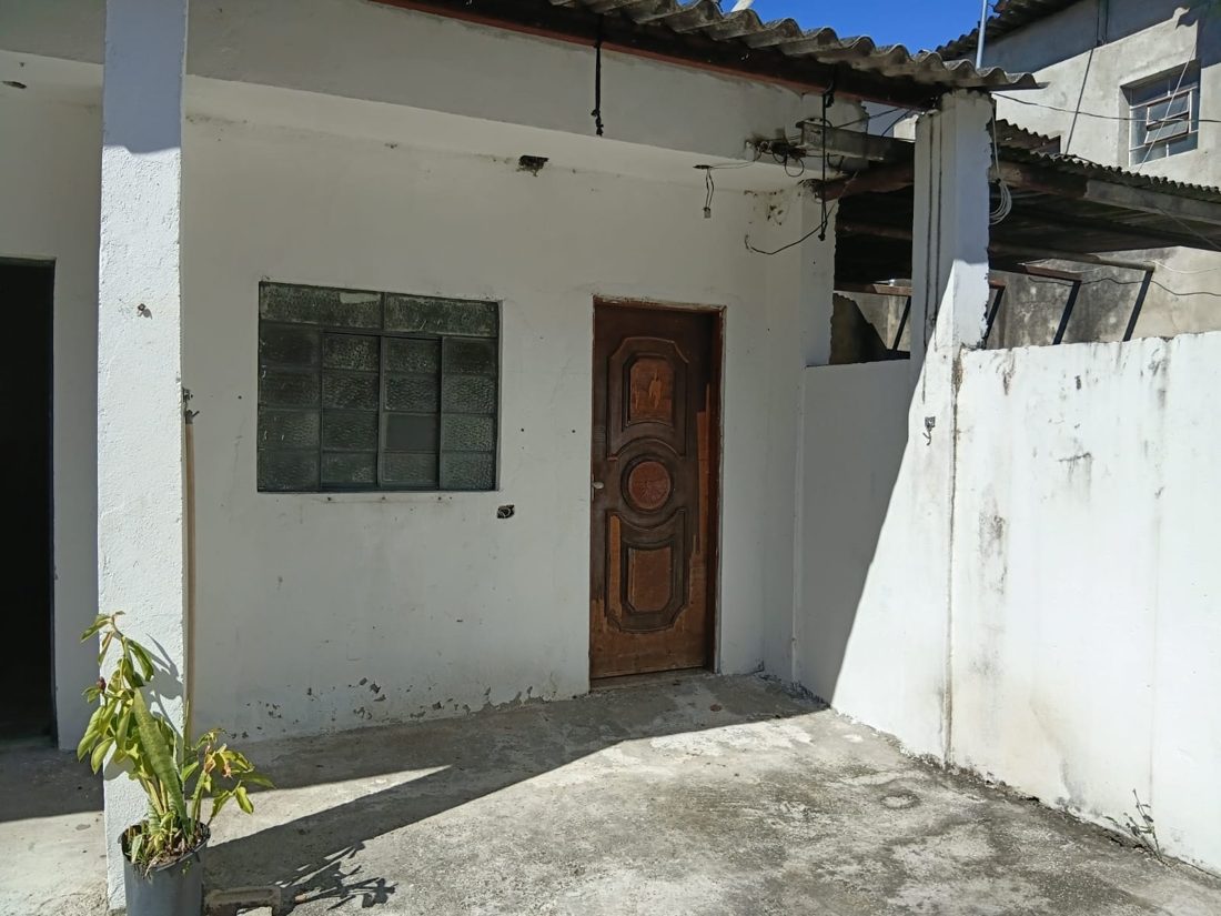 Fachada da casa, com porta de madeira e área na frente