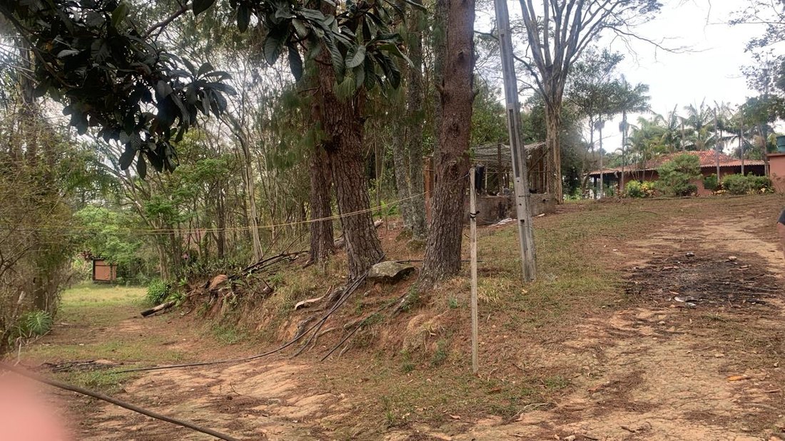 Entrada da propriedade, com cerca e árvores